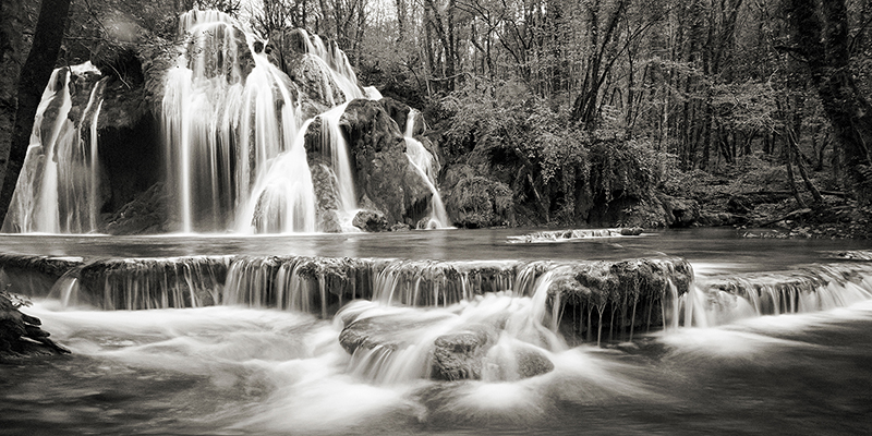 Pangea Images, Waterfall in a forest (BW)