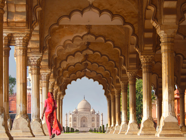 Pangea Images, Woman in traditional Sari walking towards Taj Mahal